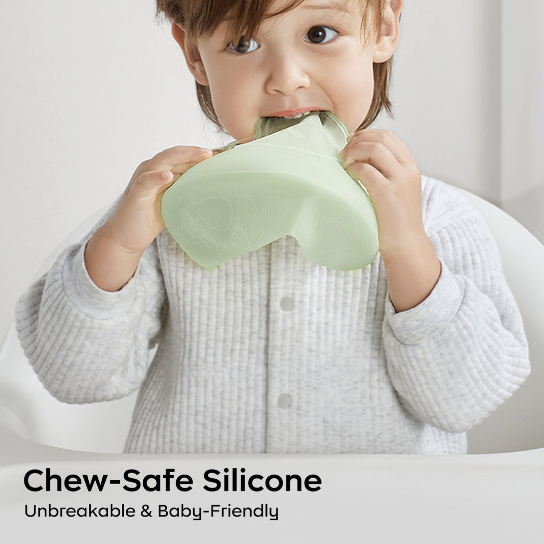 Baby chewing on a soft, chew-safe silicone bib during mealtime.