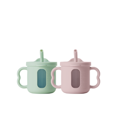 Two seesip silicone cups with handle  on a white background, one blue and one pink