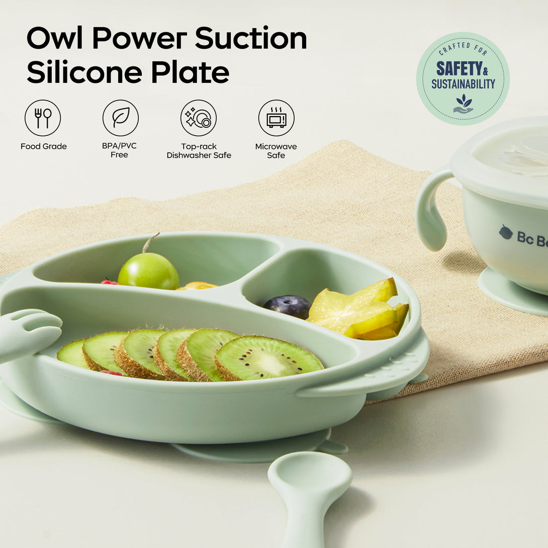 An Owl-shaped silicone plate with fruits on a table. Tags: Food Grade, BPA/PVC Free, Dishwasher Safe，Microwave safe (top-left). SAFETY & SUSTAINABILITY logo (top-right)